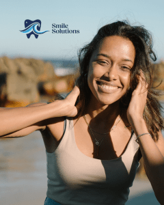 Woman smiling at the beach with the smile solutions logo